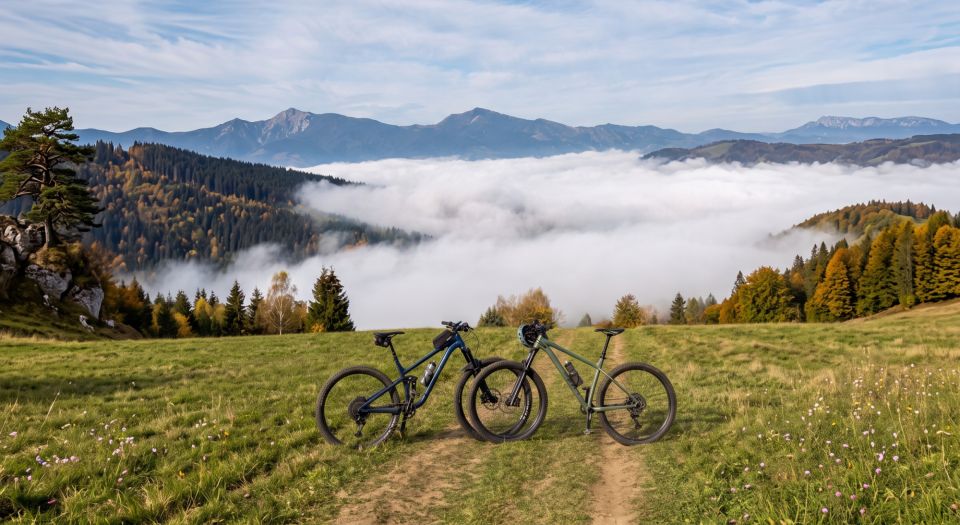 Mountain bikes on a meadow above a sea of fog, mountains behind